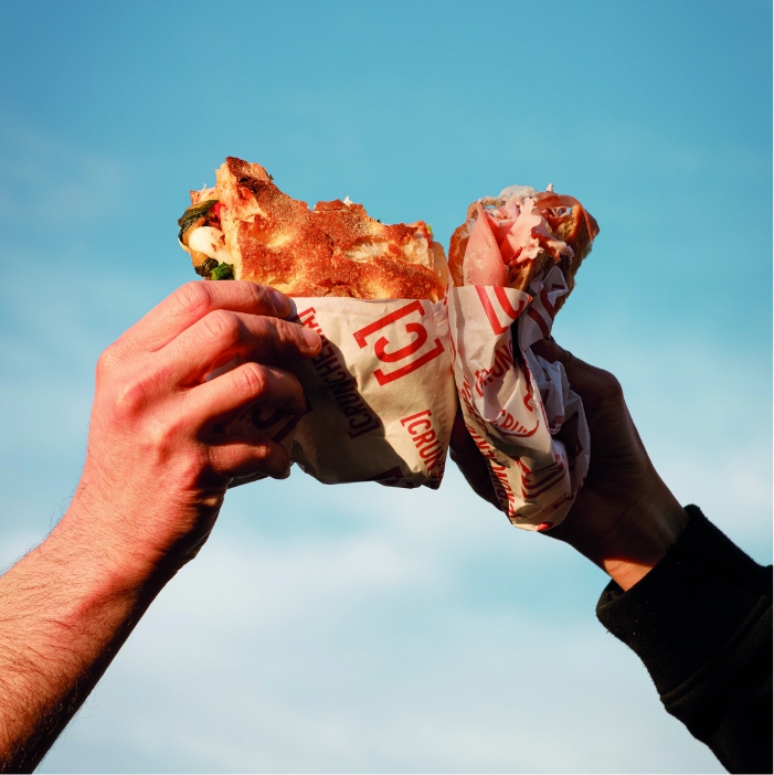 due persone mangiano la pizza doppio crunch di renato bosco